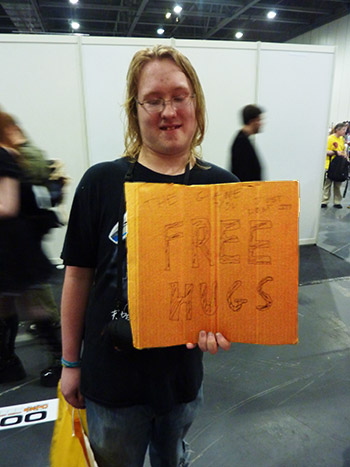 Some dude delivers a masterclass in how not to carry a "free hugs" sign.